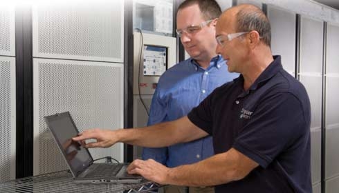 Un employé Schneider Electric aide un homme à comprendre les résultats sur une machine.