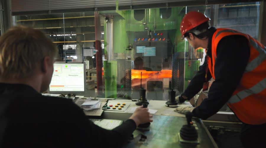 Engineers in steel forge control room, industrial automation, safety products