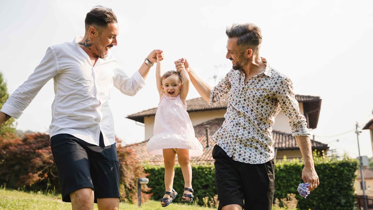 young homosexual couple playing with their baby girl