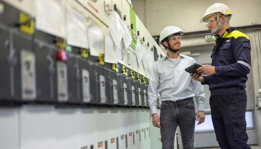 two service technicians analyzing the condition of UPS modular batteries using digital tablet
