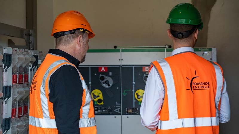 Men in orange vests and helmets