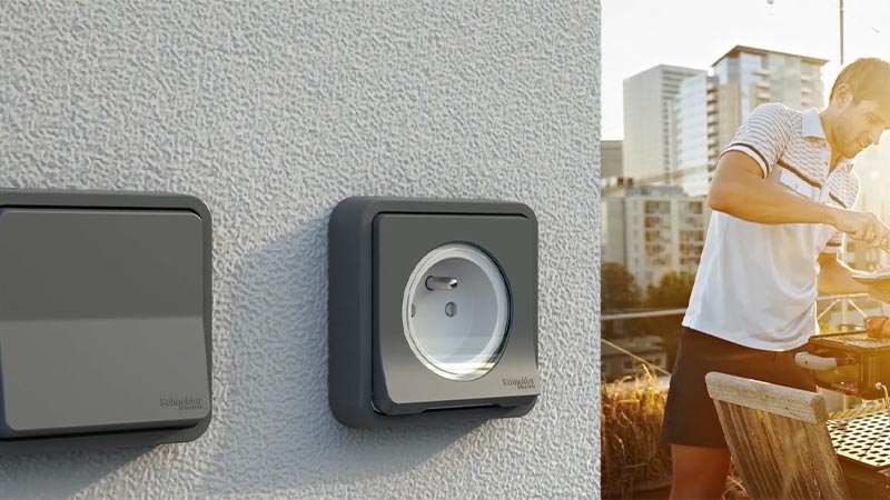 A person standing next to a wall outlet