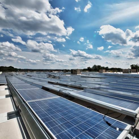Eine Dachanlage mit 1.034 Solarmodulen, die ausreichend Energie von der Sonne absorbieren, um 295 Kilowatt pro Stunde zu produzieren.