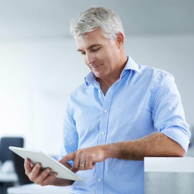 Businessman surfing the internet on his tablet, internet of things.