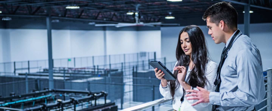 Business people using digital tablet over server room.