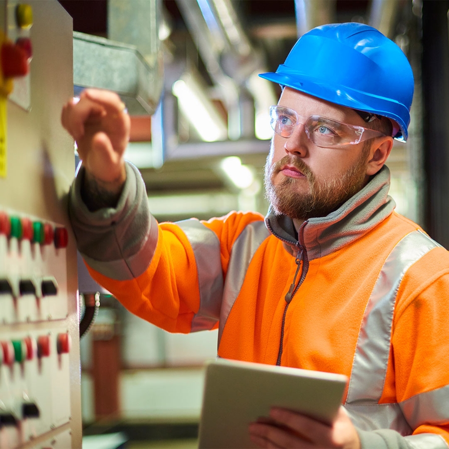 man in blue hard hat pressing a button