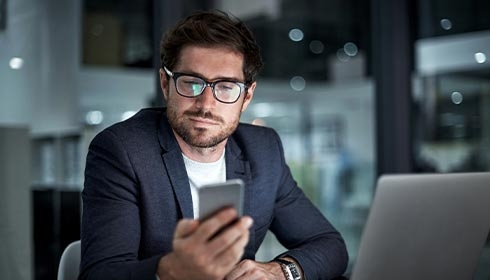 A person in a suit looking at a phone