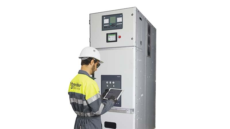 A person wearing a hard hat and overalls using a tablet