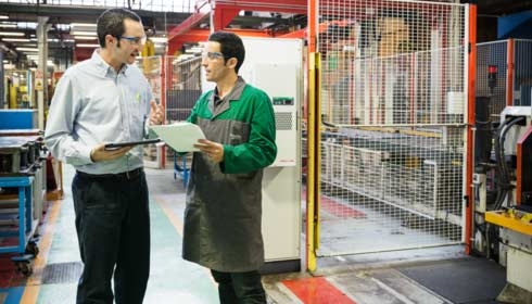 Des techniciens Schneider Electric discutent de production industrielle et d'automatisation