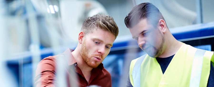 Jonge mannen die werken in een productie-omgeving