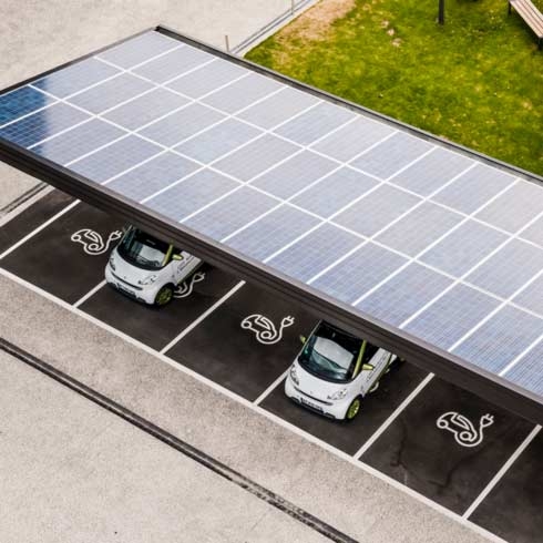 Elektrische auto's worden geladen in een carport met zonnepanelen.