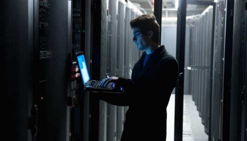 IT-technicus die computerapparatuur programmeert in een serverruimte