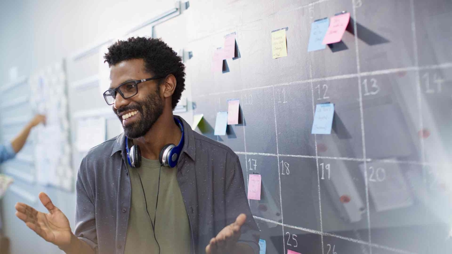 man in front of a calendar on blackboard