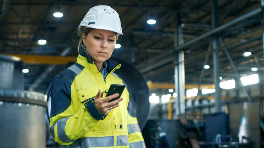 female engineer using cell phone at a factory