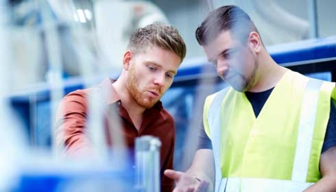 Jovem trabalhando em instalação de fabricação