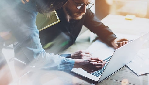 Employees discussing about a project on a computer
