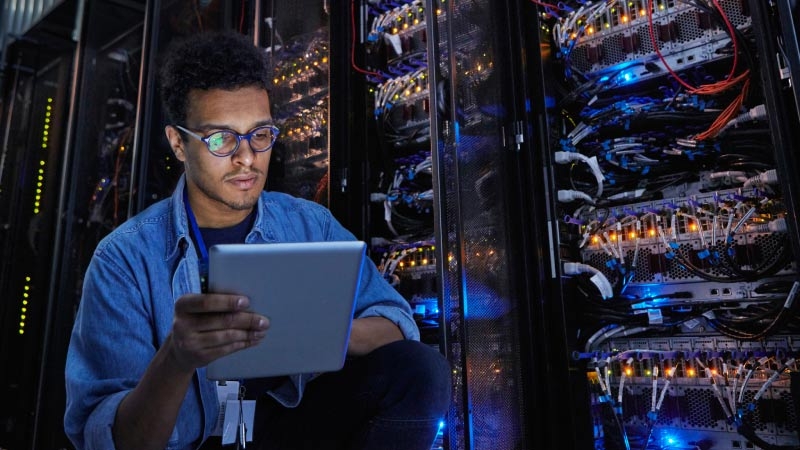 engineer is working on his tablet in server room