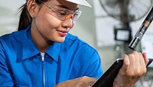 A person wearing safety goggles and a white hat