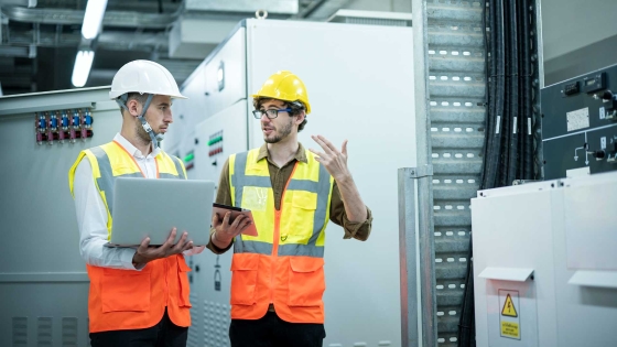 A group of men wearing safety vests and helmets