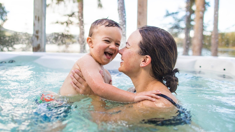 Mother playing with his baby in swimming pool