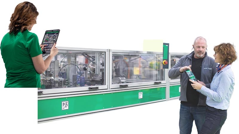 A person holding a tablet in front of a machine