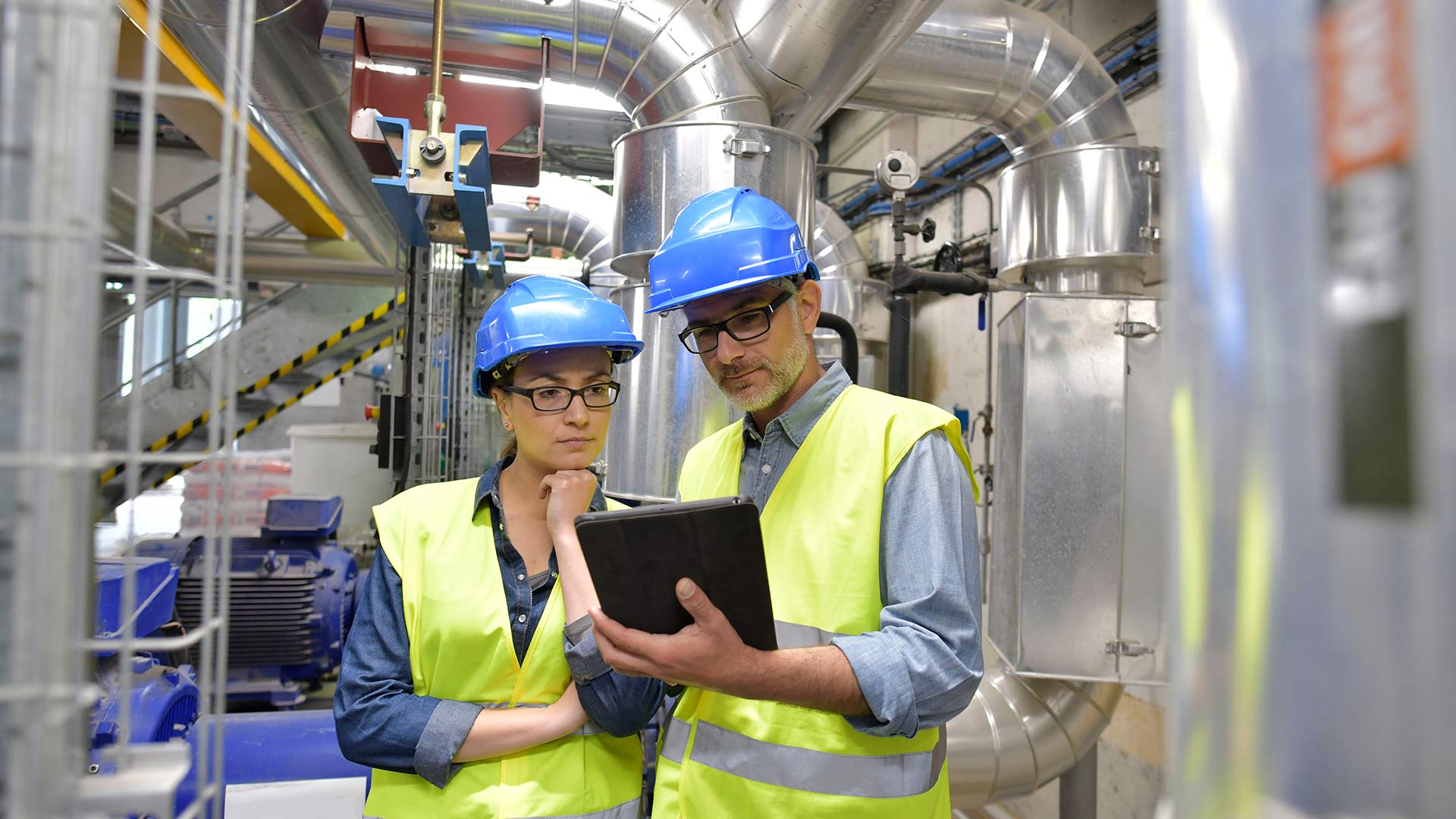 Two Engineers looking in tablet in a factory
