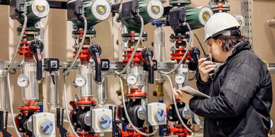 Employee taking notes in a boiler room.