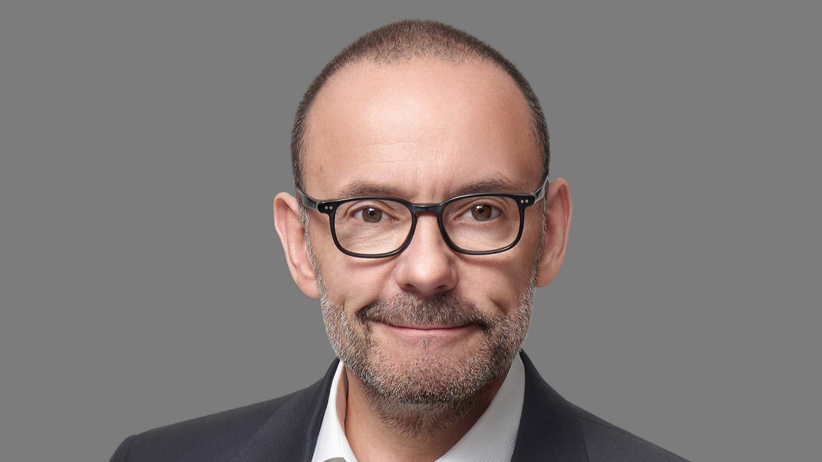 A person wearing glasses and a suit