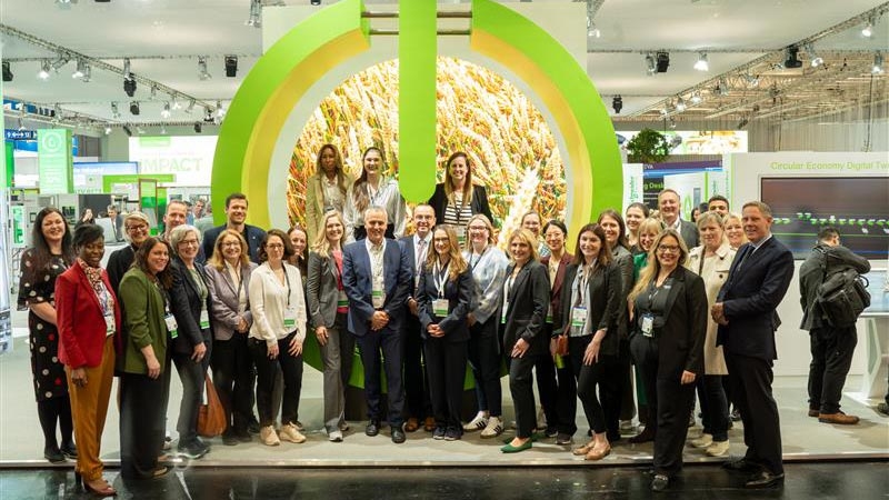 A group of people standing in front of a green and yellow arch