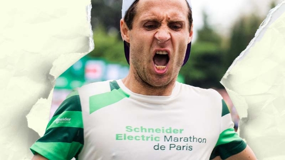 A group of people standing in front of a green and yellow arch