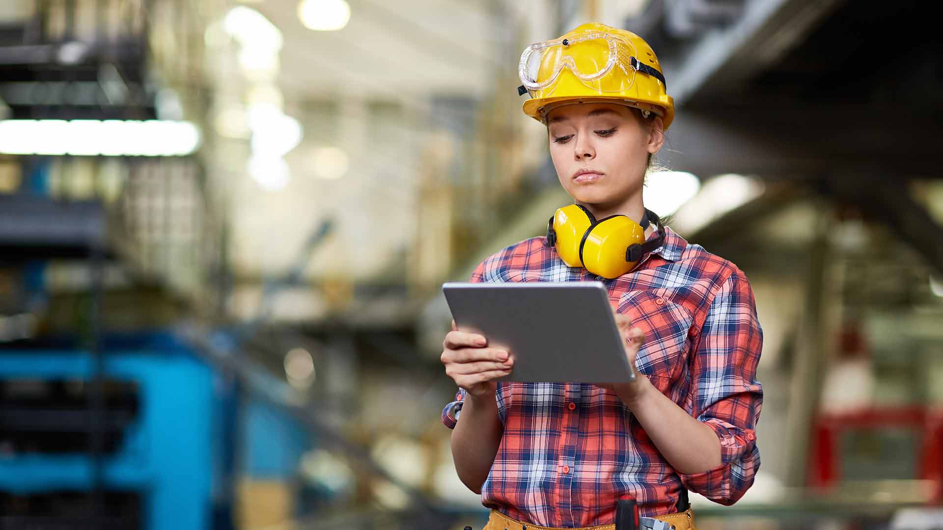 an industrial woman engineer with tablet standing in a factory