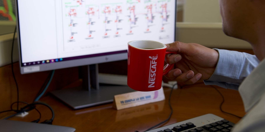 An employee in office holding his Nescafe coffee mug