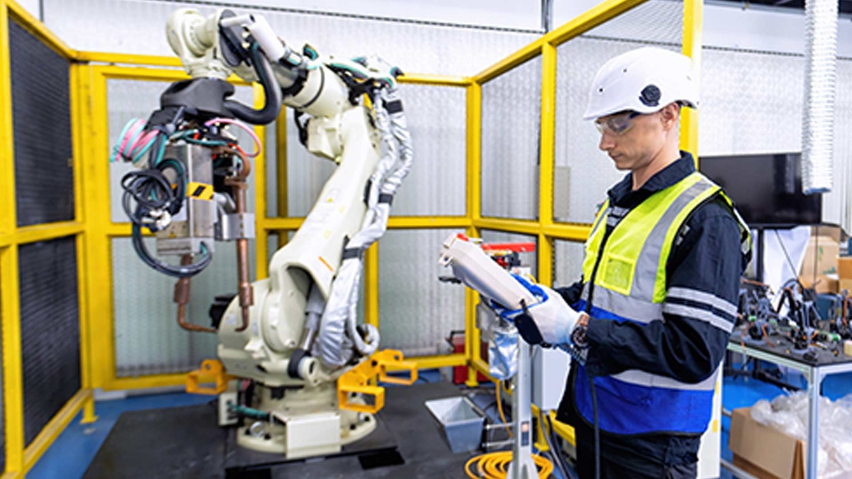 Hombre leyendo un texto cerca a un brazo de robot