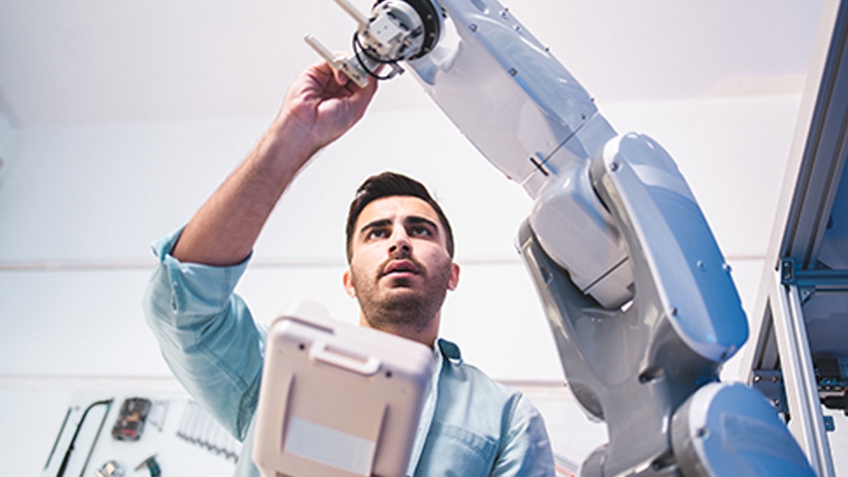 Hombre interactuando con un brazo robótico