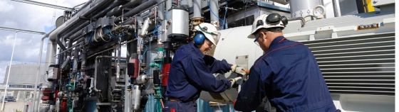A person in a blue uniform working on a machine