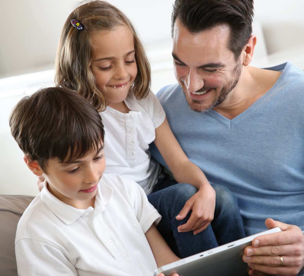Children with daddy at home using digital tablet
