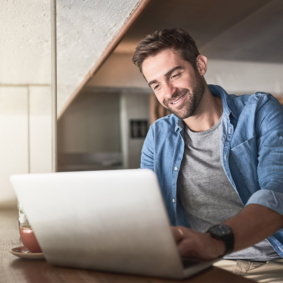 Cheerful man using laptop