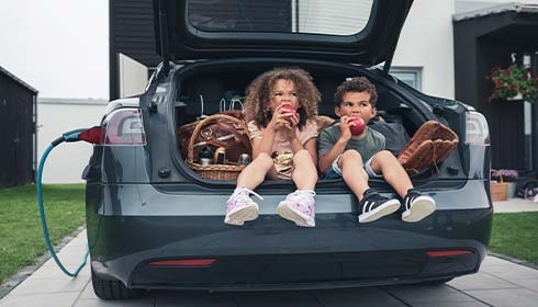 A couple of kids sitting in the trunk of a car