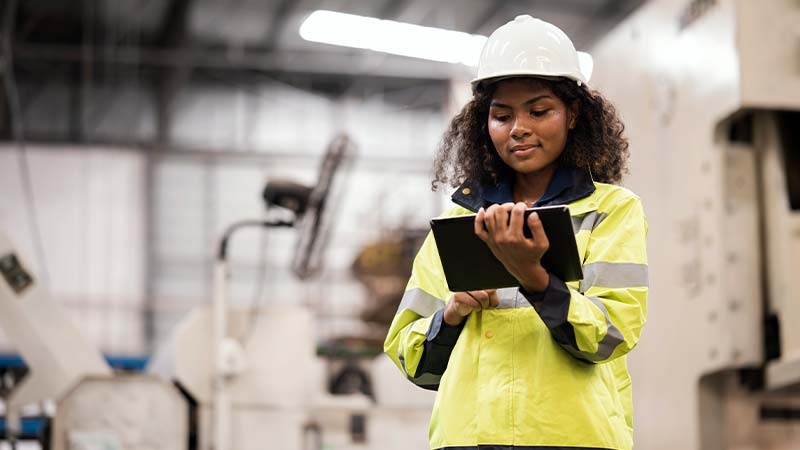 A person in a hard hat using a tablet