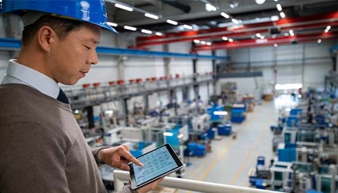 A person in a hard hat using a tablet