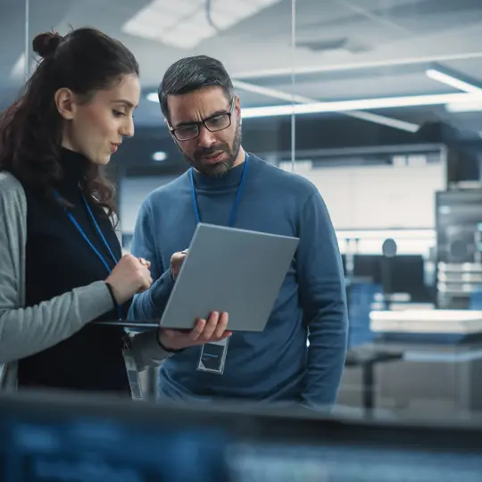 Two people looking at the laptop