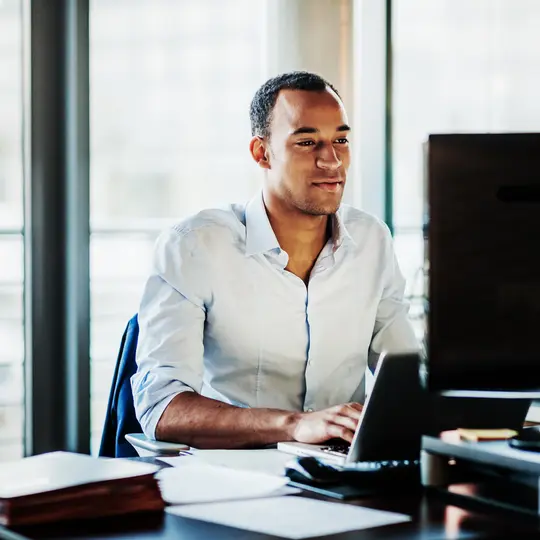 An office worker using working at his desk using a computer to review data