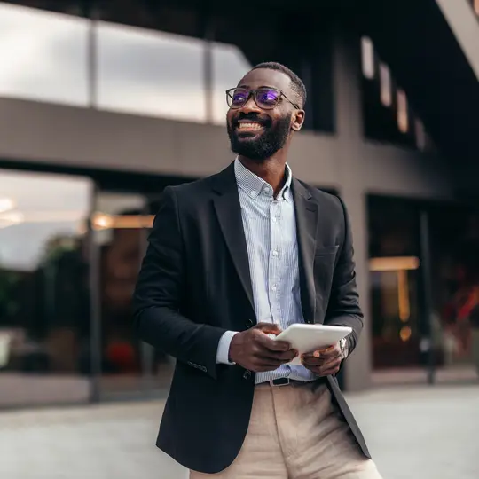 A person in a suit holding a tablet