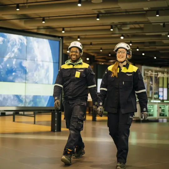 Cadres dirigeants portant des casques à côté d’un grand écran