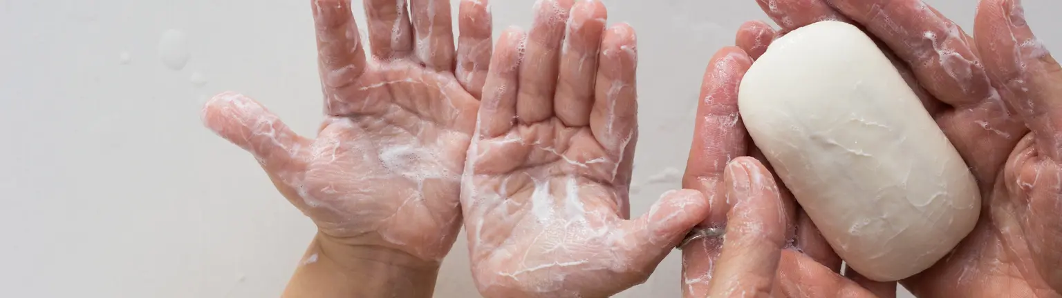 Persons washing hands with soap
