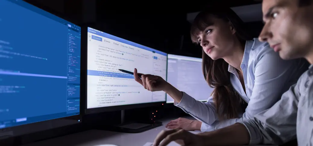 woman pointing with pen at computer screen