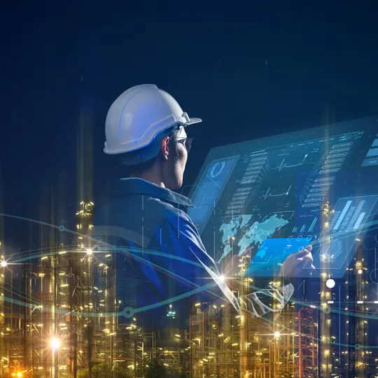 A person wearing a hard hat and holding a tablet