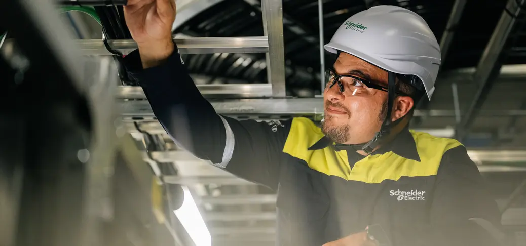 Une personne portant un casque de protection et travaillant sur une charpente métallique