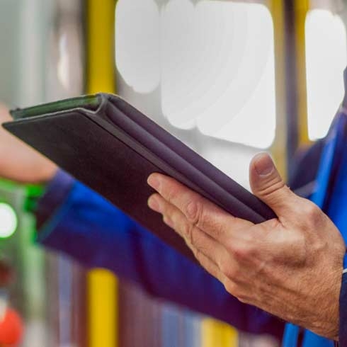 Panoramabild der Hände eines Technikers, der ein digitales Tablet hält und ein Bedienfeld verwendet.