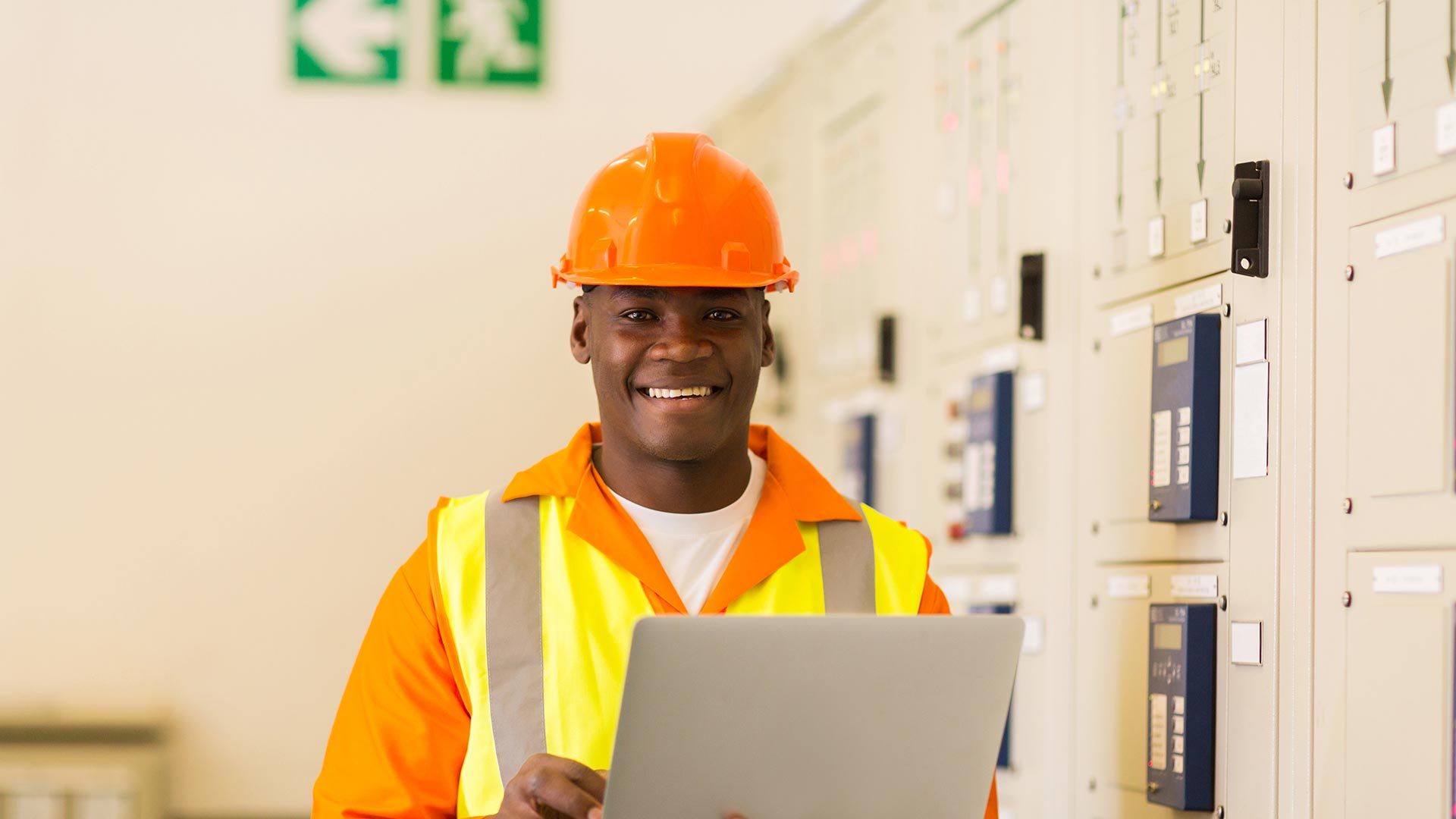 Man wearing hard hat with a laptop in hand